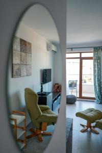 a living room with a chair and a television at Obzor Tatyana Apartaments Art in Obzor