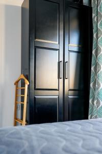 a black closet with a wooden ladder next to a bed at Obzor Tatyana Apartaments Art in Obzor