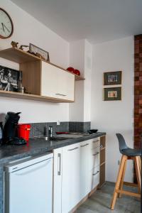 a kitchen with white cabinets and a sink and a chair at Obzor Tatyana Apartaments Art in Obzor