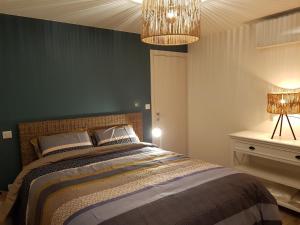 a bedroom with a bed and a chandelier at Maison sur la Presqu'Ile de Rhuys in Saint-Gildas-de-Rhuys