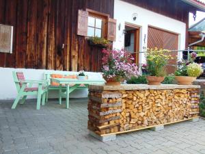 a patio with a table and chairs and flowers at Ferienwohnung Baumgartner in Bad Hindelang +49 photos