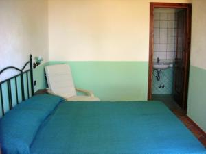 a bedroom with a bed and a chair and a sink at Agriturismo Nakelia in Zambrone