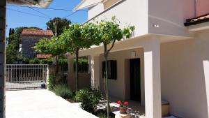 a white house with a tree in front of it at House Mergi 2 in Pomer