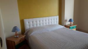 1 dormitorio con 1 cama blanca y 2 lámparas en las mesas en B&B La Sirena, en Santa Teresa di Riva