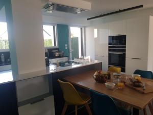 a kitchen with a wooden table and chairs at Maison sur la Presqu'Ile de Rhuys in Saint-Gildas-de-Rhuys