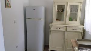 a kitchen with a white refrigerator and a cabinet at House Mergi 2 in Pomer