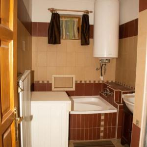 baño pequeño con lavabo y bañera en Hajnalka apartmanház, en Kehidakustány