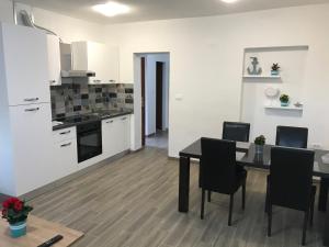 cocina y comedor con mesa y sillas en Apartments Lena en Baška
