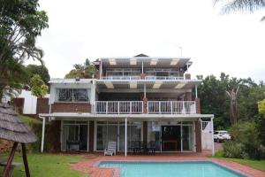 a house with a swimming pool in front of it at Ballito Clarke Bay Beach House - family holiday letting in Ballito