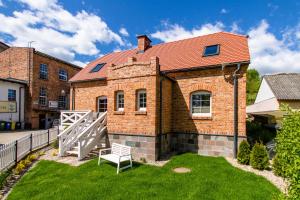 ceglany dom z ławką w ogródku w obiekcie DOMKI APARTAMENTOWE CHMIELÓWKA w Chmielnie