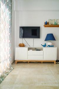 a living room with a tv and a white cabinet at Obzor Tatyana Apartaments Bonjour in Obzor