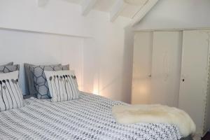 Un dormitorio blanco con una cama con una manta. en Het Wijdeland en Zwolle