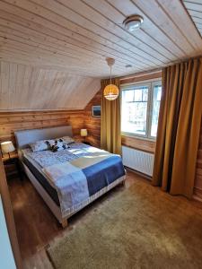 1 dormitorio con cama y techo de madera en Autumn Leaf Ivalo, en Ivalo