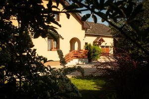 a large white house with a porch and a yard at Hajnalka apartmanház in Kehidakustány