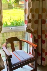 a wooden chair sitting in front of a window at Ellen House Bed and Breakfast in Matlock