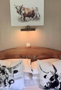 a bedroom with two beds and a picture of cows at Ellen House Bed and Breakfast in Matlock
