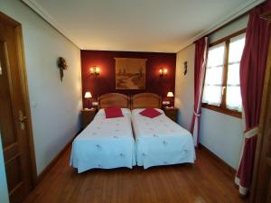 um quarto com uma cama com duas almofadas vermelhas em Aldalurberea em Etxalar