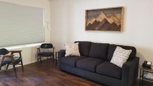 a living room with a black couch and chairs at Eagle Cap Chalets in Joseph