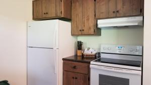 a kitchen with a white refrigerator and wooden cabinets at Eagle Cap Chalets in Joseph
