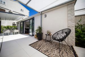 een patio met een rotan stoel op een tapijt bij First apartment Zadar in Zadar