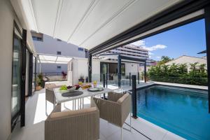 een patio met een tafel en stoelen naast een zwembad bij First apartment Zadar in Zadar