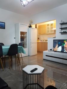 a living room with a tv and a kitchen at Apartman Višković Koromačno in Koromačno