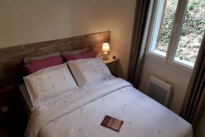 a bedroom with a bed with a book on it at Vue panoramique sur le château,montagne et grottes in Fontaine-de-Vaucluse