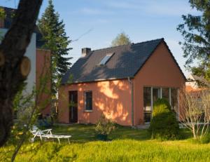 una casa con un banco delante de ella en Hospoda-Ferienhaus am Olba-See en Malschwitz