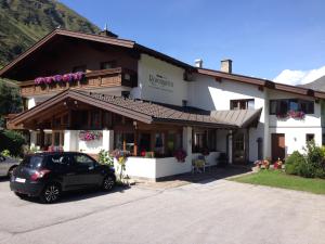 a building with a car parked in front of it at Appartement Rosengarten in Obergurgl