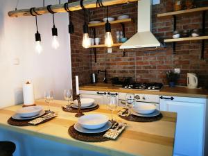 a kitchen with a table with plates and wine glasses at Holiday Home Bulog in Sinac