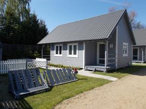 une petite maison avec une clôture devant elle dans l'établissement Bałtyckie Siedlisko, à Jarosławiec