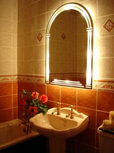 e bagno con lavandino, specchio e vasca. di AbbeyCourt Kenmare Kerry a Kenmare