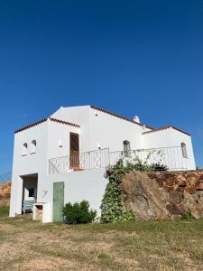 una casa blanca sentada en la cima de una colina en la casa della tartaruga, en San Pantaleo