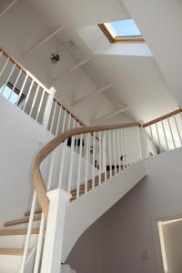 a white spiral staircase in a house with a skylight at Munkebjerg Bed & Breakfast in Børkop