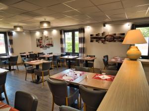 - une salle à manger avec des tables et des chaises dans l'établissement Contact Hotel Restaurant La Chaumière Les Mureaux-Flins, aux Mureaux