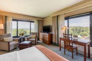 Habitación de hotel con cama, escritorio y TV. en The Omni Grove Park Inn - Asheville, en Asheville