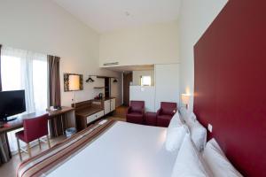 a hotel room with a large white bed and red walls at Best Western Plus City Hotel Gouda in Gouda