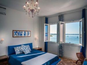 a bedroom with a blue bed and a large window at Casa Sulla Laguna in Murano