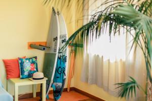 Zimmer mit 2 Surfbrettern, einem Tisch und einer Pflanze in der Unterkunft Peniche Beach House in Peniche