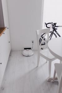 ein weißes Zimmer mit einem Fahrrad und einem weißen Stuhl in der Unterkunft Apartments Wisniowa with private parking place in Breslau