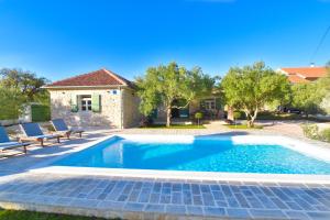 a swimming pool in front of a house at Vacation Home Mate Ceko in Sukošan
