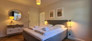 ein Schlafzimmer mit einem großen Bett mit weißer Bettwäsche in der Unterkunft The Old Mill - By the Lake - 2 Bedroom Apartment in Kruså