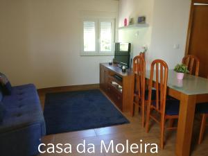 a living room with a table and a desk with a tv at Casa da Moleira in Amares