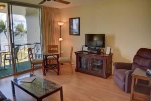 ein Wohnzimmer mit einem Sofa und einem TV in der Unterkunft Hale Kai O'Kihei 309 in Kihei