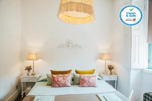 a bedroom with a bed with pillows and two lamps at Dona Fina Guest House in Mirandela