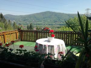 a table with a vase of flowers on a balcony at Chata Panorama Beskidów in Ustroń +11 photos