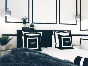 1 dormitorio con 1 cama con almohadas blancas y negras en VUT iDesign, en Ávila