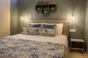 a bedroom with a bed with two pillows and lights at Lamprini's Deluxe Studios in Limenas