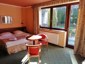 a bedroom with a bed and a table and a window at Chata Panorama Beskidów in Ustroń