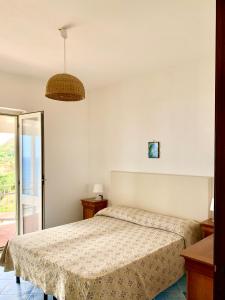 a bedroom with a bed and a glass door at Casa Siciliano in Ischia